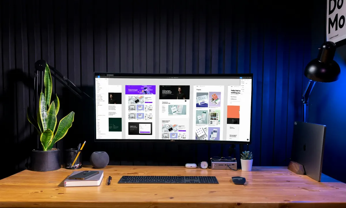 Postazione di graphic design con monitor e tavolo in legno